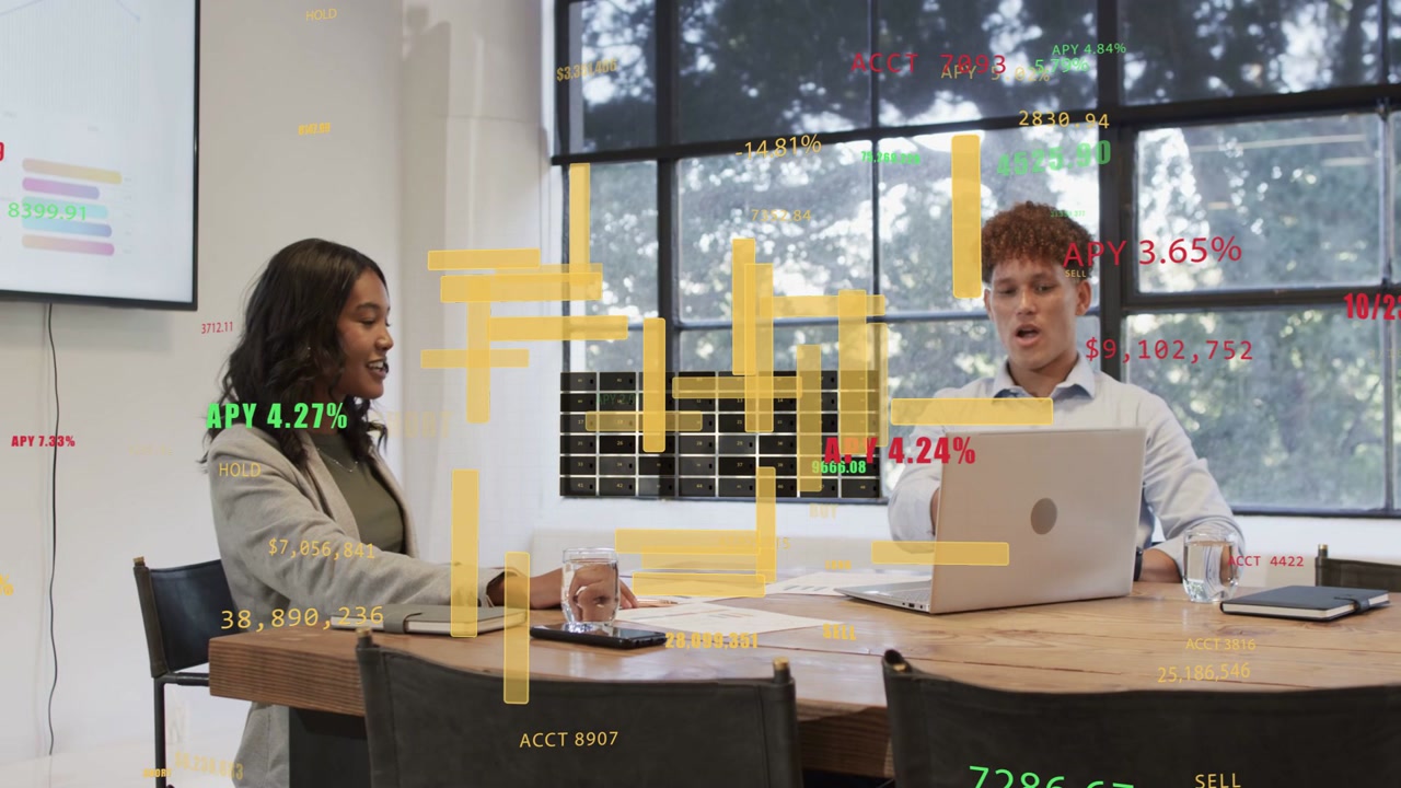 Woman leading discussion pointing at papers, man typing, analyzing finance charts overlaying laptop