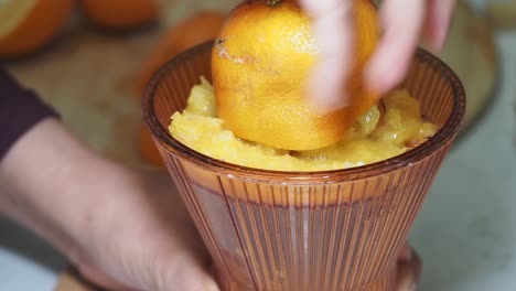 exprimir naranjas con un exprimidor de mano