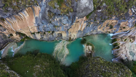 amazing drone shot of the beautiful millpu lake with turquoise waters in ayacucho, peru during an afternoon between rocky mountains and beautiful colors