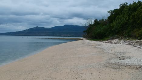 A-girl-walking-along-a-deserted-tropical-island-in-the-Pacific-Ocean-region