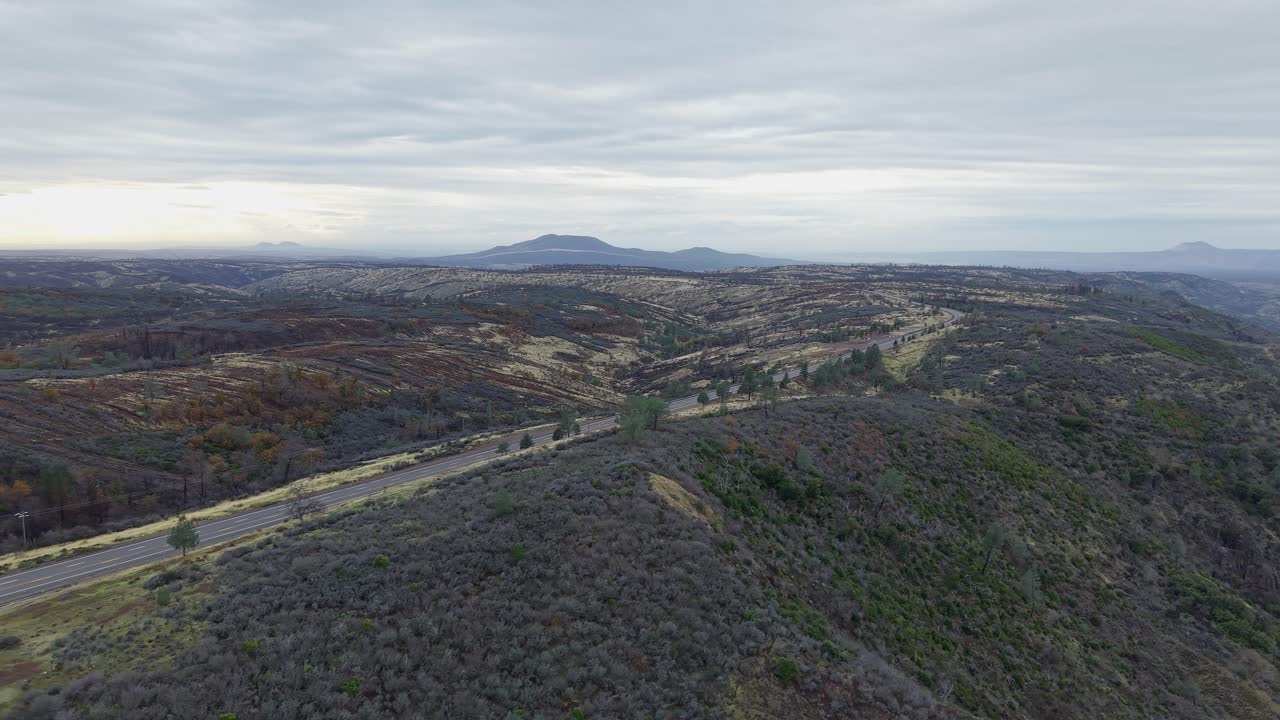 The drone surveys Paynes Creek Point from overhead, highlighting its mix of tree clusters, gentle elevations, and winding highway that define its rural character
