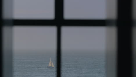 sailboats and cutter in the sea view through the window