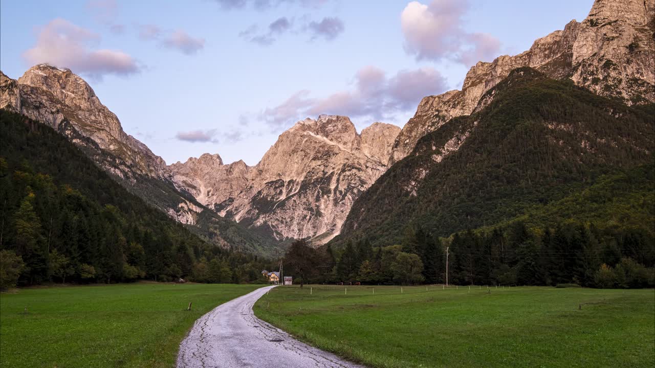 timelapse de una puesta de sol en log pod mangartom con nubes moviéndose sobre las enormes montañas de los alpes julianos, parque nacional de triglav en eslovenia