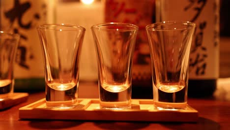 glasses of sake being clinked together in sequence