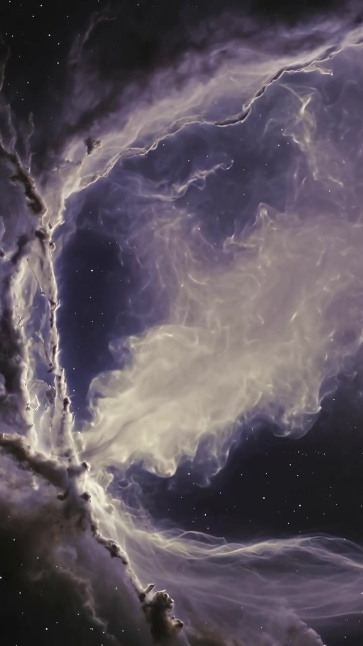 Video verticale: Telecamera che panoramica, rivelando una nebulosa con un pennacchio che si sposta, estendendo filamenti che si illuminano nello spazio.