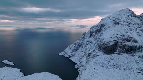high snowy mountain peaks of lofoten islands aerial view rising above idyllic blue ocean
