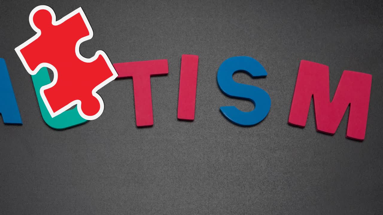 Animation of red and yellow puzzle pieces falling over autism text on grey background