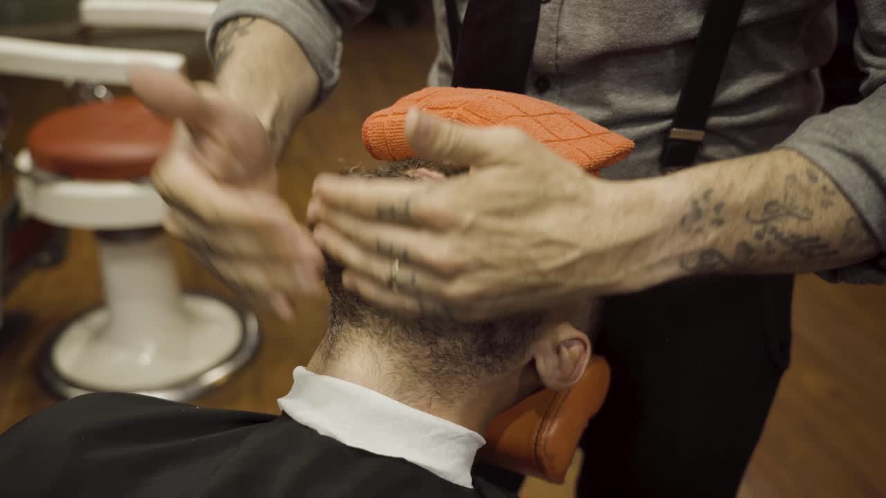 barbero haciendo masaje facial a un hombre - de cerca