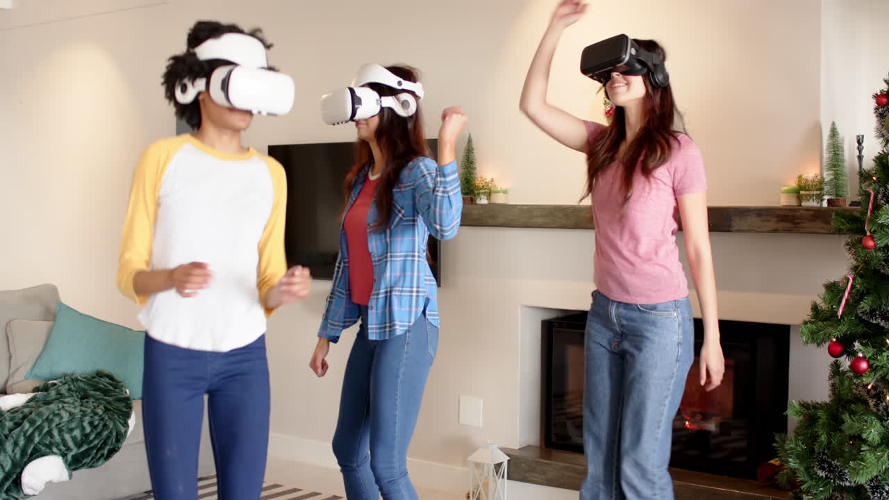 Women friends enjoying virtual reality games at home during Christmas celebration