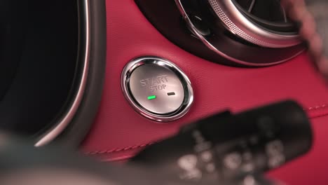 la mano del conductor está presionando el botón para arrancar el motor del coche. encendido sin llave arranque del motor. concepto de transporte y tecnología