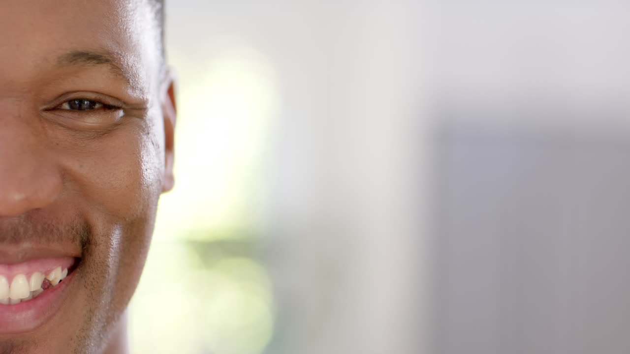 Portrait of happy african american man with short hair at home, slow motion, copy space