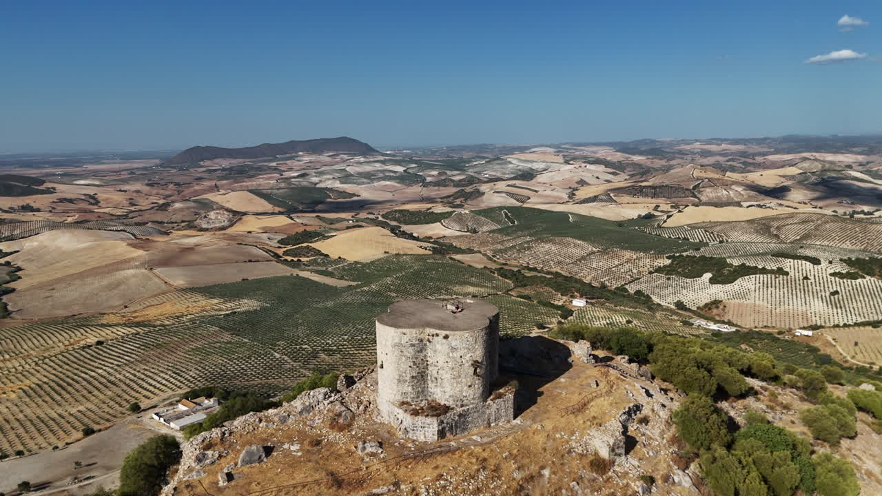 Aerial view pulling away to reveal the beautiful Cote Castle surrounded by mountains and fields in Andalusia, southern Spain