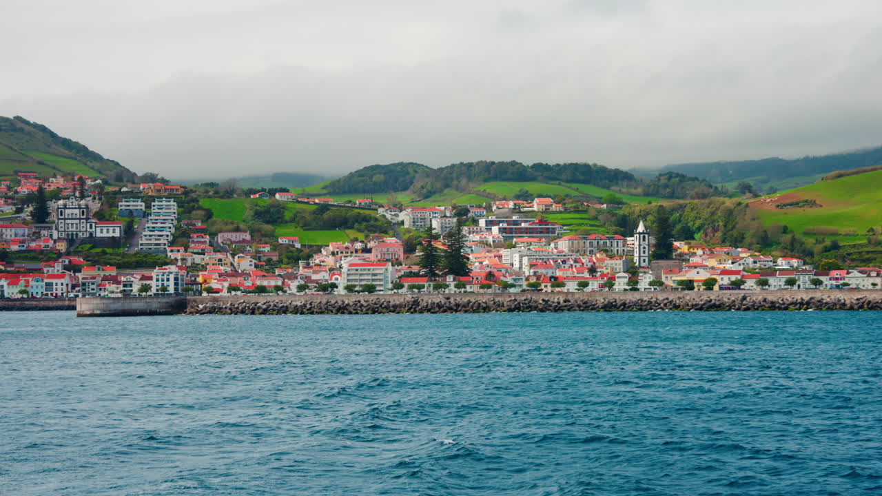 Piccola cittadina locale con tetti arancioni situata sulla costa rocciosa delle Isole Azzorre, Oceano Atlantico, Portogallo