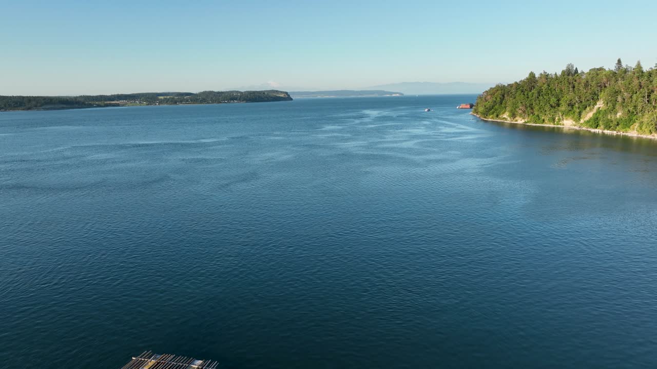 Luftoptagelse, der forlader Penn Cove muslingefarms anløbsbroer og flyver ud i bugten.