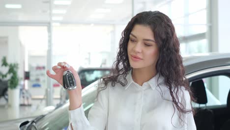 woman with car keys at a car dealership