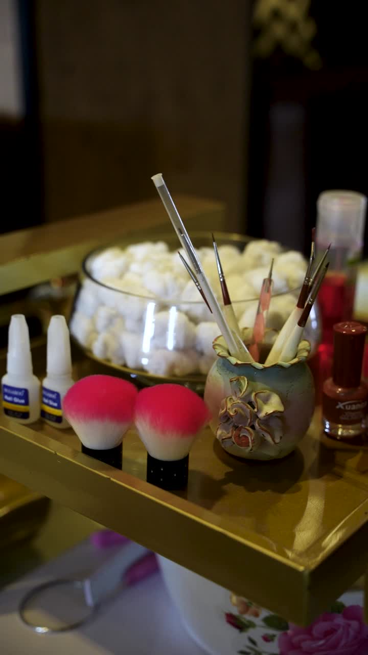 Salon tray with nail art brushes, polishes, buffers, and a bowl of cotton balls neatly arranged