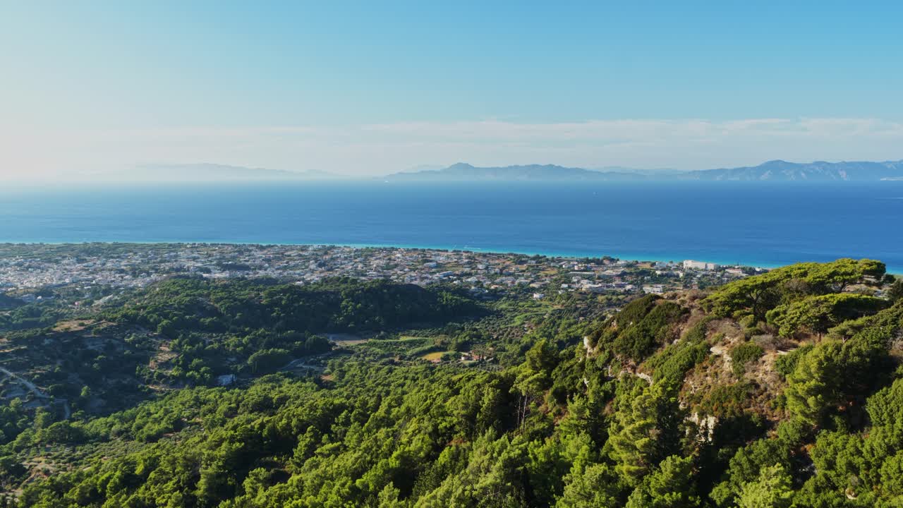 Scenic aerial view of a coastal town with mountains and lush greenery