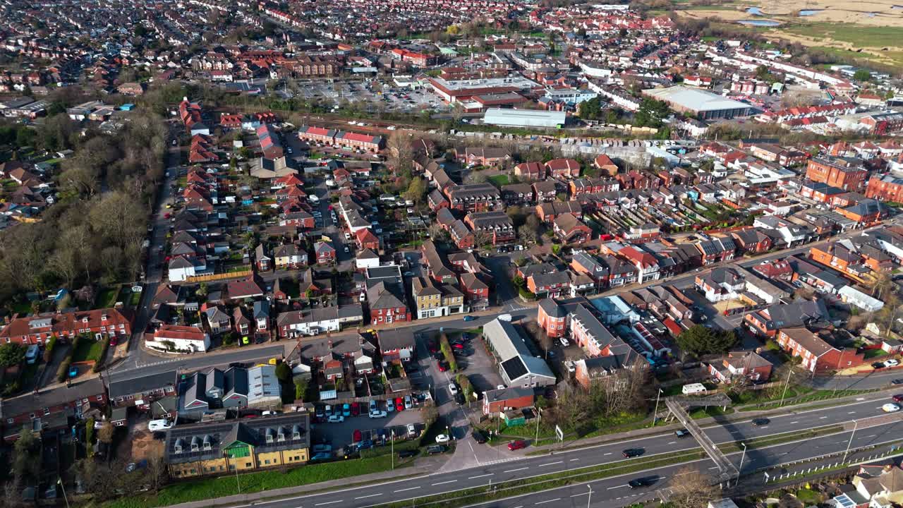 Panorerande flygfoto över förorten Totton väster om floden i Southampton, England, med bilar som kör på de livliga vägarna och solljus som reflekteras på det blå flodvattnet med båtar på under vintern.