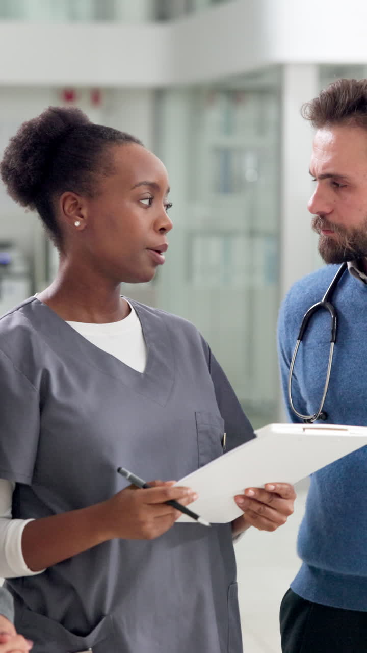 Professionisti del settore medico discutono della cura del paziente nel corridoio di un ospedale