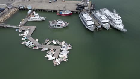 aerial view away from a ferry docking at the port of plymouth, usa - tilt, drone shot