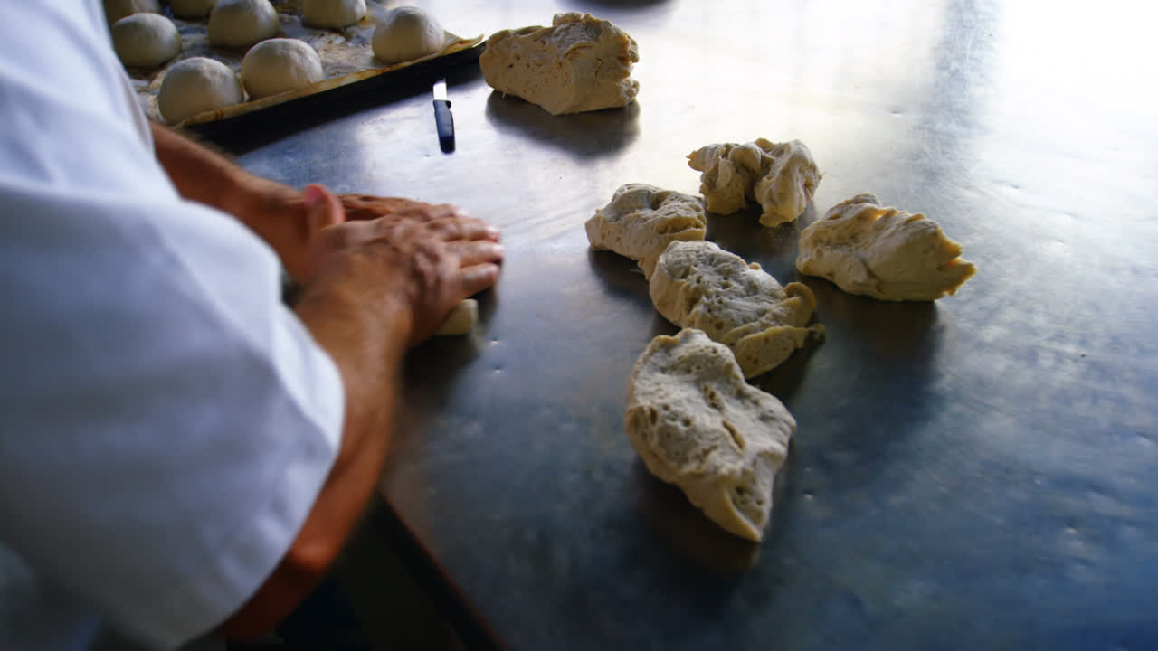 Male chef preparing kneaded dough in bakery shop 4k