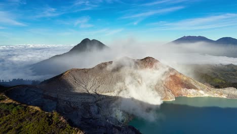 right-orbit aerial circles kawah ijen at sunrise, revealing its turquoise acidic lake, steaming sulfur mine and multicolored caldera walls above east java’s mist-shrouded mountains