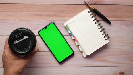 workspace with phone, notebook, and coffee cup