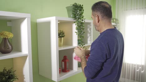 mature man cleaning at home alone happy and in good spirits.