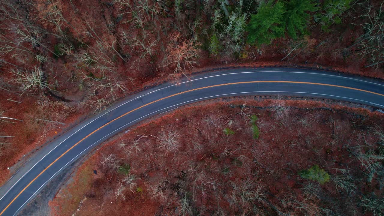 imágenes de video de drones aéreos de arriba hacia abajo de una hermosa carretera de montaña durante el otoño en las montañas apalaches, con luz dorada al atardecer