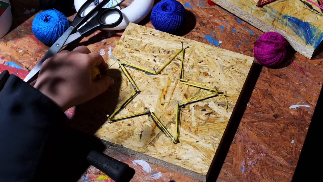 niños, durante talleres prácticos, martillar clavos en formas y crear decoraciones con hilo