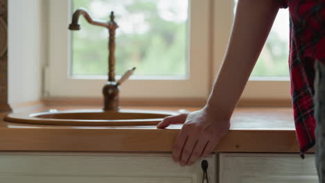 woman standing by kitchen sink