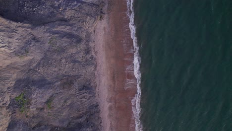 英國多塞特郡尤拉紀海岸的綠海波浪和懸崖上空拍攝的無人機