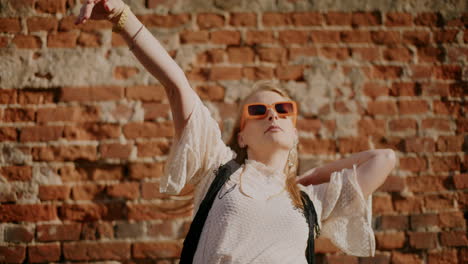 woman posing outdoors by a brick wall