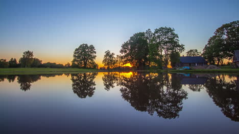 beautiful golden sunset on a lake with a remote house in latvia, timelapse