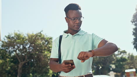 teléfono, tiempo y negocios hombre negro en la ciudad esperando
