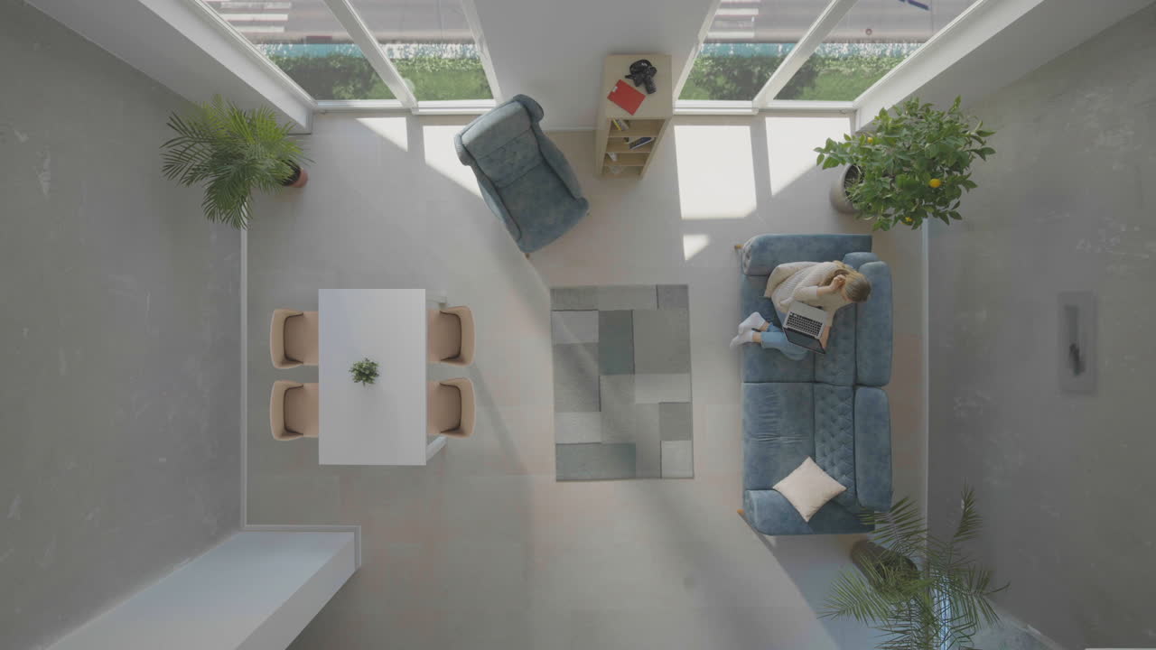 mujer sentada en el sofá con una computadora portátil