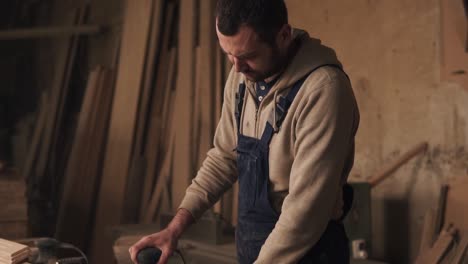 Una-Filmación-De-Un-Carpintero-Trabajando-Con-Un-Mono.-Un-Hombre-Moliendo-Una-Madera-En-Un-Taller-De-Carpintería.-Camara-Lenta