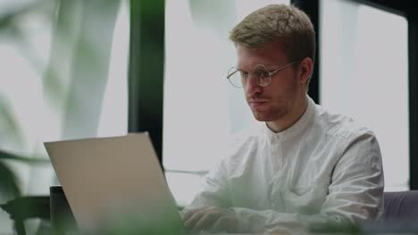 office worker is sending emails and making report in laptop, portrait in office of large successful company