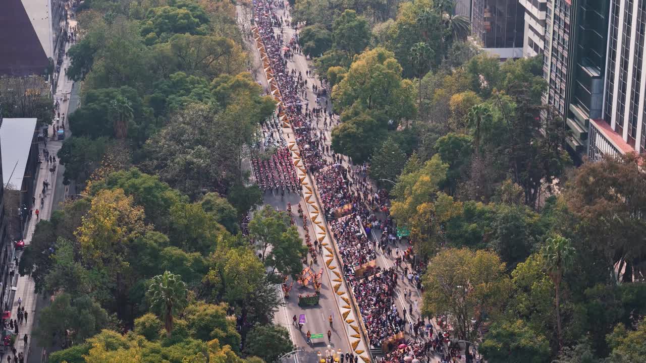 Aerial shot flying over Paseo de la Reforma during the Day of the Dead parade in Mexico City
