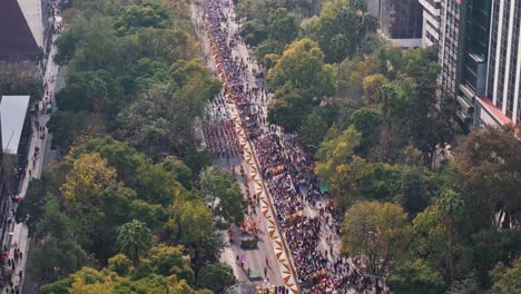 aerial shot flying over paseo de la reforma during the day of the dead parade in mexico city