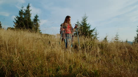 Woman-hiking-with-trekking-poles-in-mountains