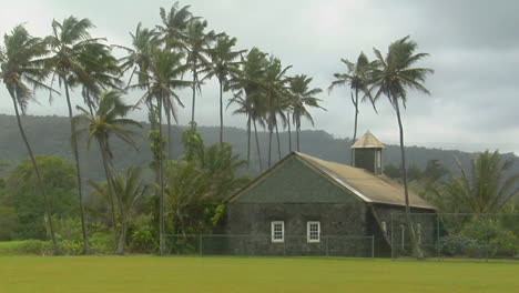 a church stands on a tropical island during a wind storm