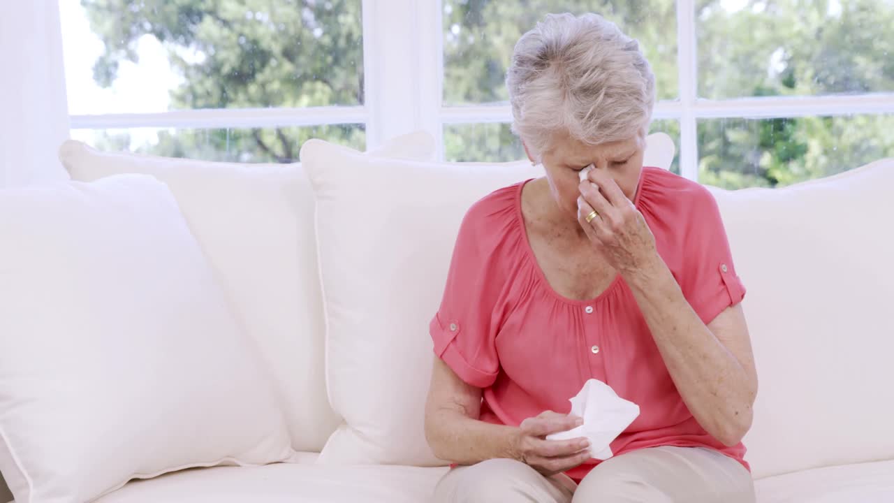 mujer mayor llorando en el sofá