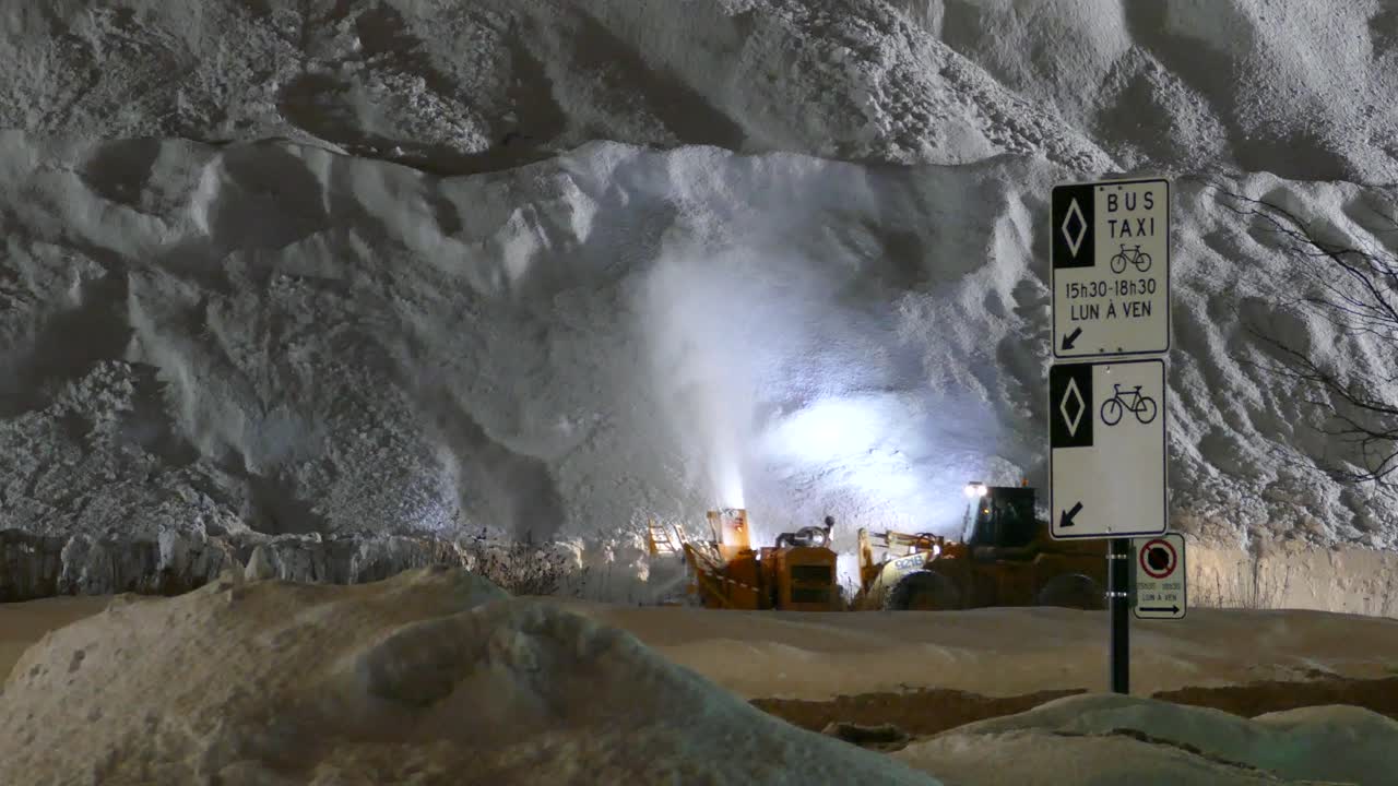 tractor quitar la nieve en la carretera durante la tormenta de nieve