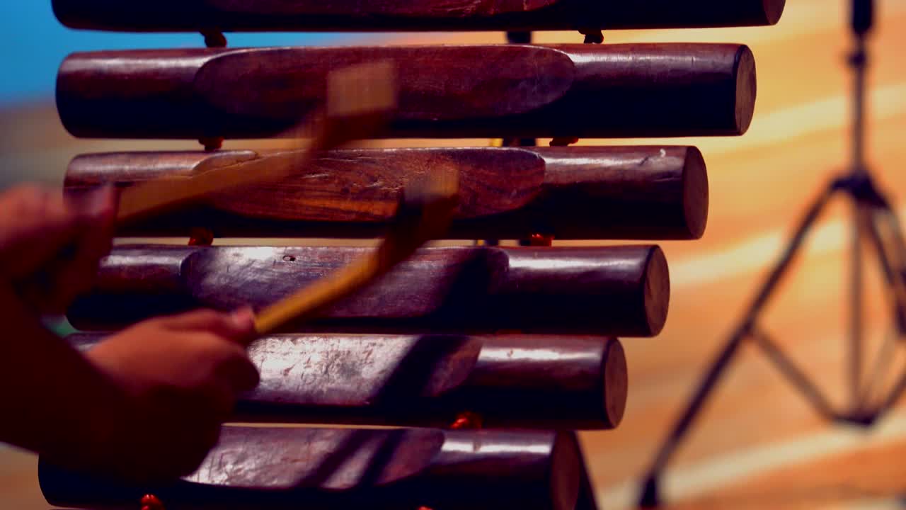 Close up hand hitting or playing pong lang or a log xylophone from the Isan region of northeast Thailand.