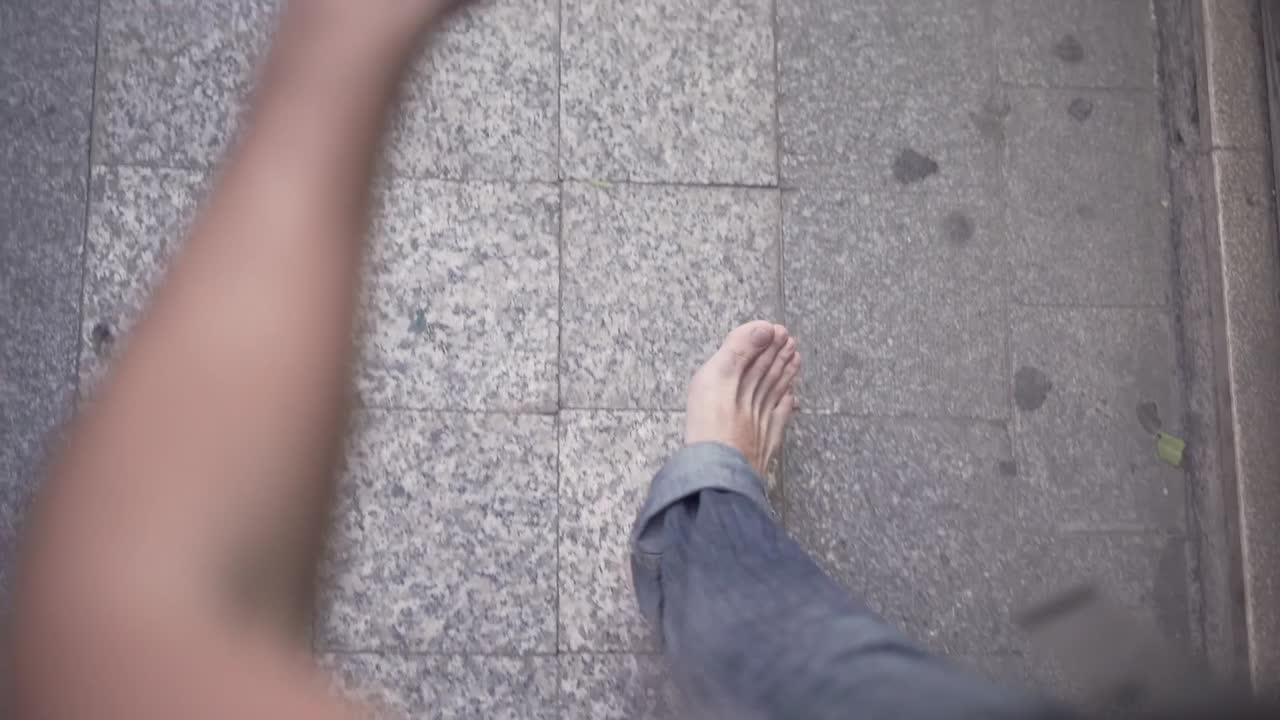 Person walking on a tiled pavement