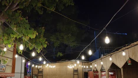 steady shot of a decorated yellow glowing light bulbs at night