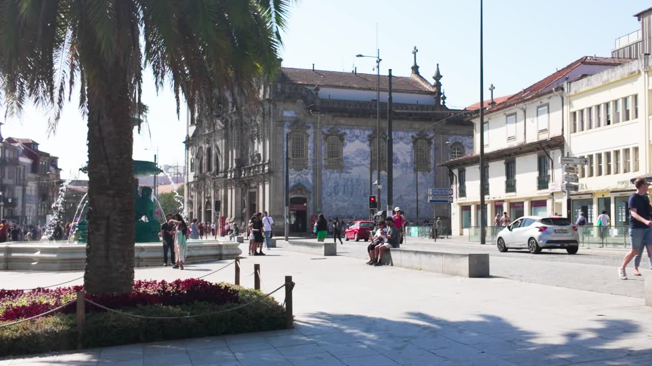 People walk by the historic University of Porto building on a sunny day