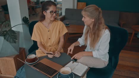 dos mujeres trabajando juntas en una cafetería