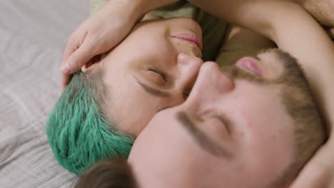 close up of a happy couple embracing and cuddling on the bed at home